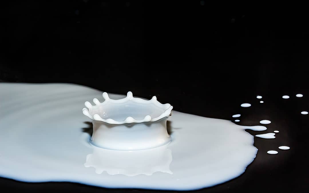 white milk splashing on black counter
